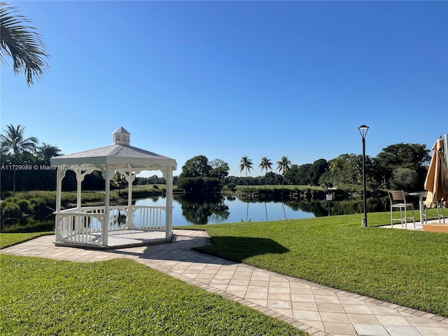 view of dock with a yard, a gazebo, and a water view