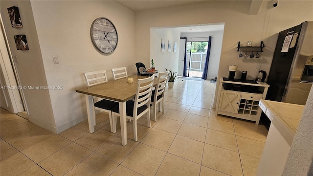 dining space featuring baseboards and light tile patterned flooring