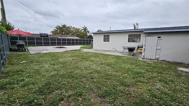 view of yard with an outdoor fire pit, a fenced backyard, and a patio