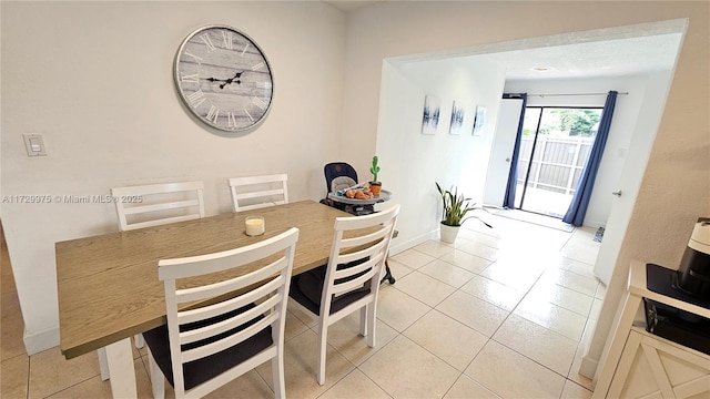 dining room with light tile patterned floors and baseboards