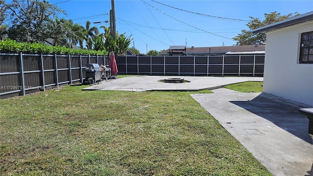 view of yard featuring an outdoor fire pit, a fenced backyard, and a patio