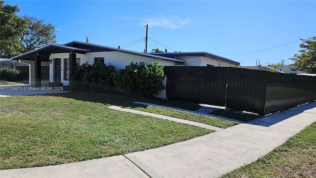 view of side of home featuring a yard, fence, and stucco siding