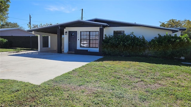 view of front facade with concrete driveway, a front lawn, and stucco siding