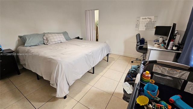 bedroom with light tile patterned flooring and baseboards