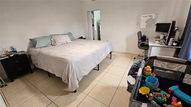 bedroom with light tile patterned floors and baseboards