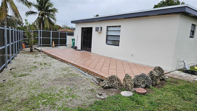 rear view of property featuring a patio area, a fenced backyard, and stucco siding