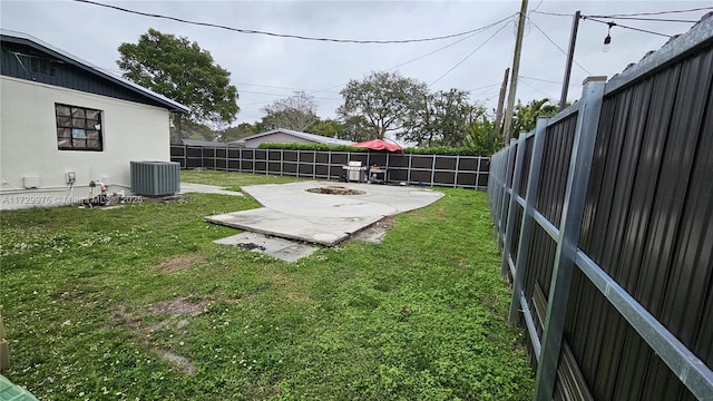 view of yard with central air condition unit, a patio area, an outdoor fire pit, and a fenced backyard