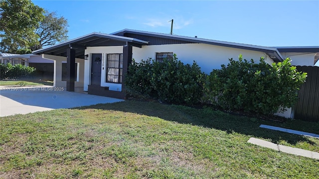 view of front facade featuring fence, a front lawn, concrete driveway, and a patio