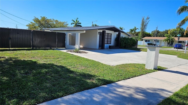 view of front of home featuring a front yard, fence, and stucco siding