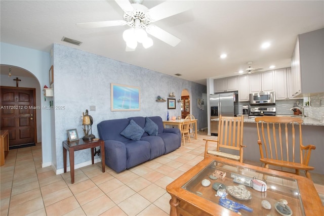 living room with visible vents, recessed lighting, arched walkways, light tile patterned floors, and ceiling fan