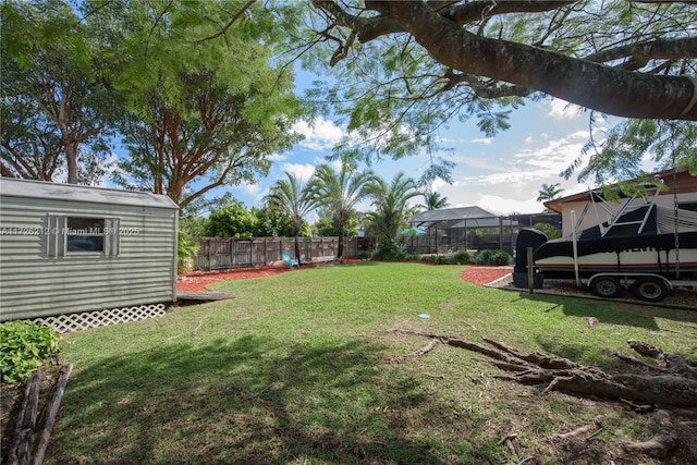 view of yard with an outbuilding, a lanai, and a fenced backyard