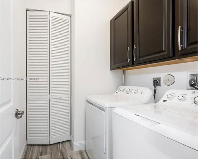 clothes washing area with light hardwood / wood-style floors, cabinets, and washing machine and clothes dryer