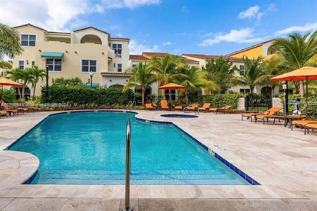 view of swimming pool with a patio area and a community hot tub