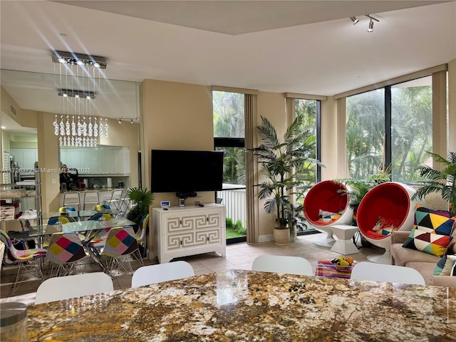 living room with floor to ceiling windows and light tile patterned floors