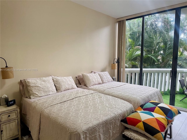 bedroom with a wall of windows and light hardwood / wood-style flooring