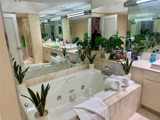 bathroom featuring vanity, tile patterned floors, and tiled bath