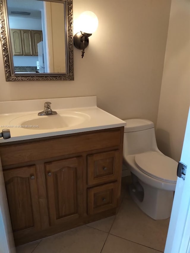 bathroom with toilet, tile patterned flooring, and vanity