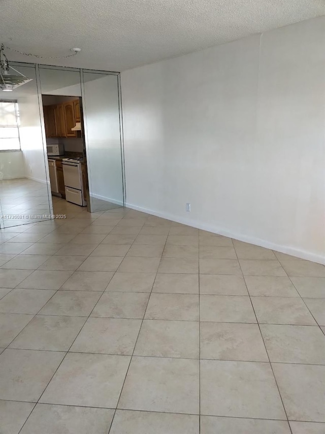 tiled spare room with a textured ceiling