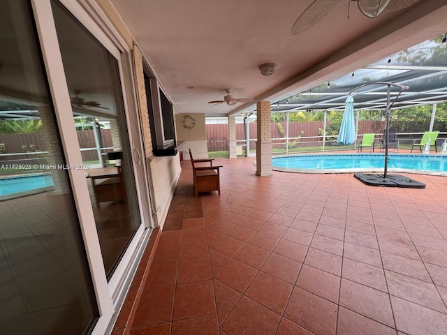 view of swimming pool featuring ceiling fan, a patio, and a lanai