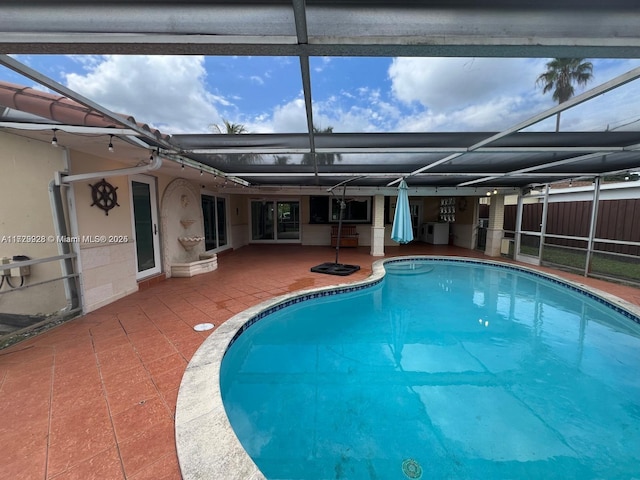 view of pool with a patio area and a lanai