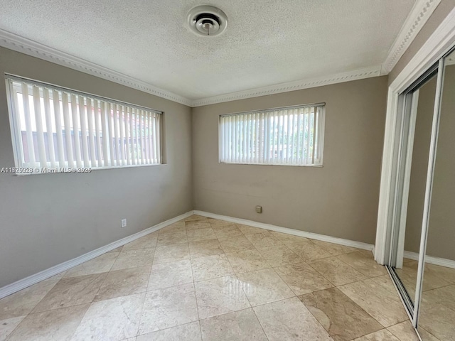 unfurnished bedroom with a textured ceiling, a closet, and ornamental molding