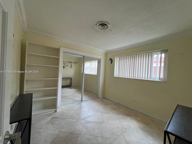 unfurnished bedroom featuring a closet, a textured ceiling, and multiple windows