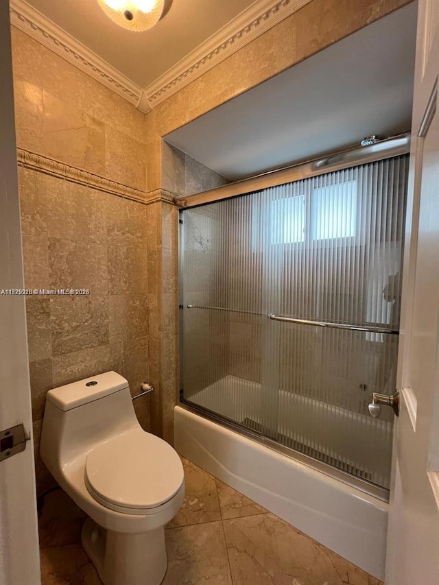 bathroom with crown molding, bath / shower combo with glass door, toilet, and tile patterned floors