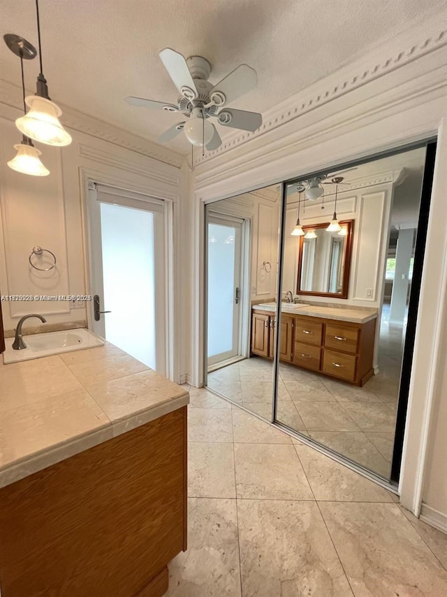 bathroom featuring ceiling fan, a textured ceiling, and vanity