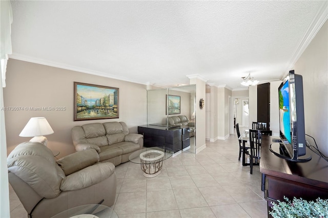 living room featuring an inviting chandelier, a textured ceiling, light tile patterned floors, and ornamental molding