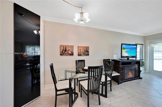 tiled dining area with a notable chandelier, ornamental molding, and a textured ceiling