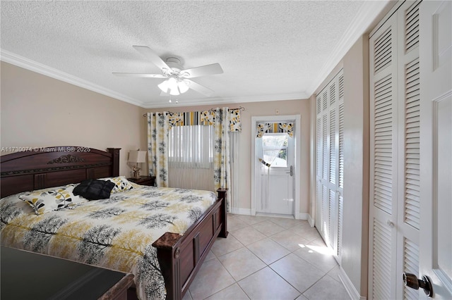 tiled bedroom with multiple closets, ceiling fan, and ornamental molding