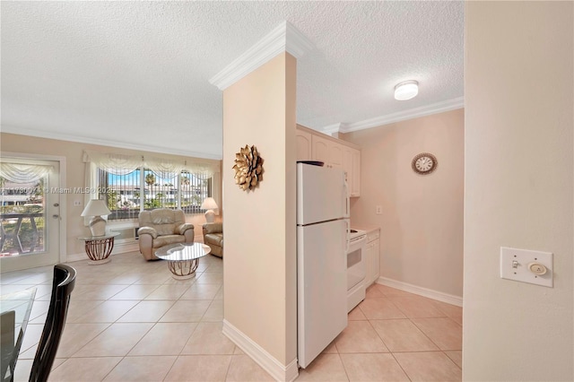 kitchen with white appliances, crown molding, a textured ceiling, white cabinetry, and light tile patterned floors