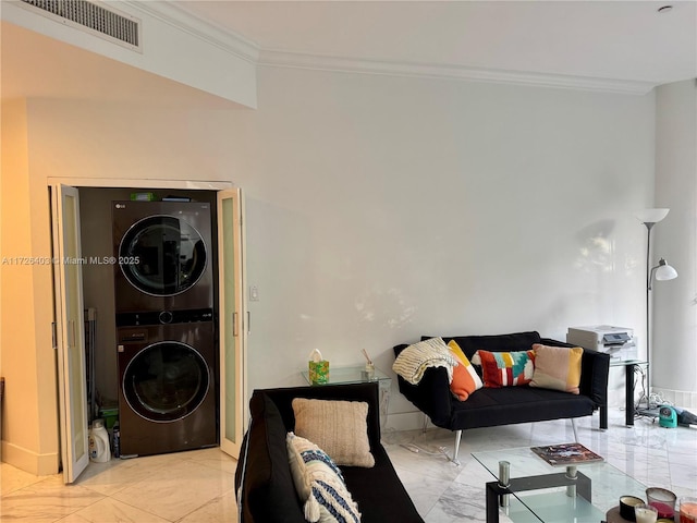 living room featuring crown molding and stacked washer / dryer