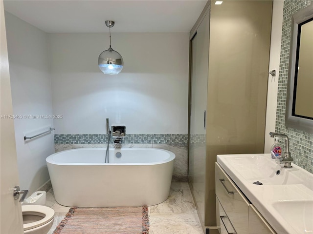 bathroom with a washtub, toilet, and vanity