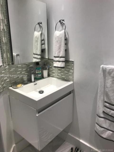 bathroom featuring tasteful backsplash and vanity