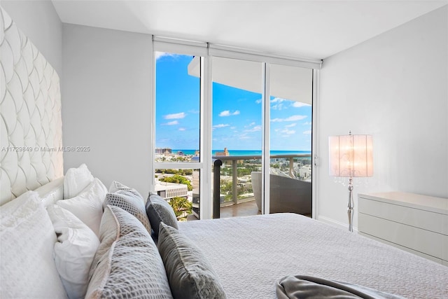 bedroom with a wall of windows, access to outside, and a water view