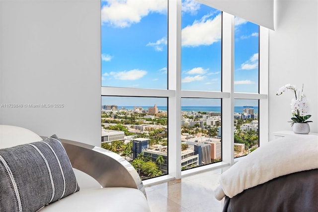 bedroom featuring a water view, expansive windows, and a towering ceiling