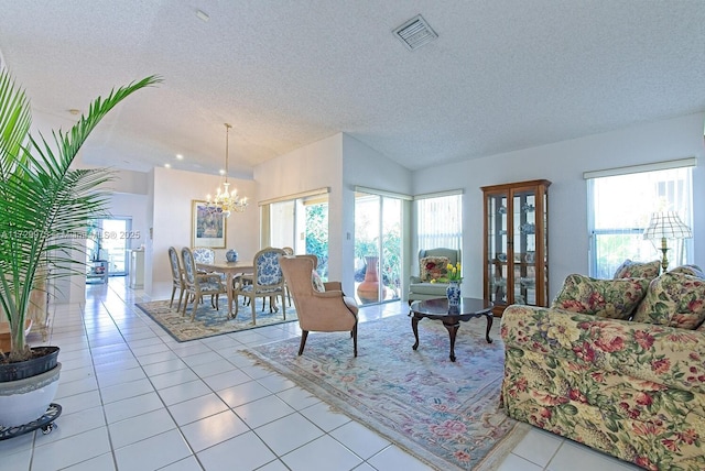 tiled living room featuring lofted ceiling, a textured ceiling, a chandelier, and a healthy amount of sunlight