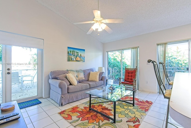 living room with lofted ceiling, light tile patterned floors, a textured ceiling, and ceiling fan