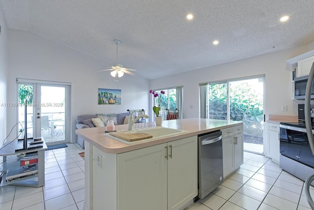 kitchen with vaulted ceiling, white cabinetry, sink, a kitchen island with sink, and stainless steel appliances