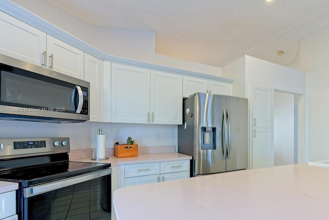 kitchen featuring appliances with stainless steel finishes, a textured ceiling, and white cabinets