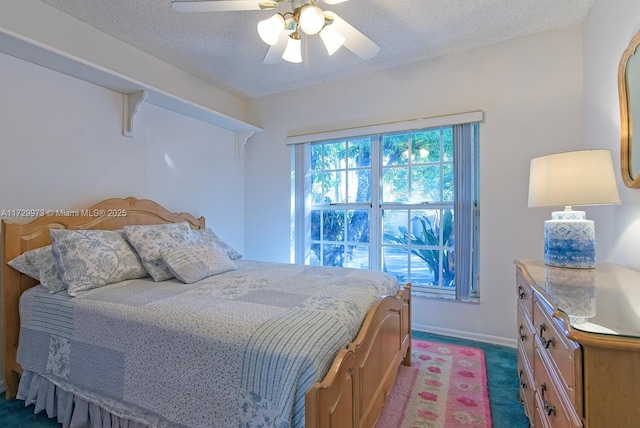 carpeted bedroom featuring ceiling fan and a textured ceiling