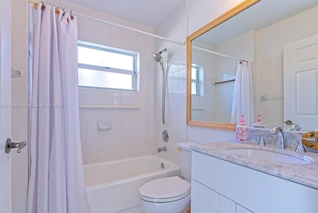 full bathroom featuring vanity, shower / bathtub combination with curtain, and toilet