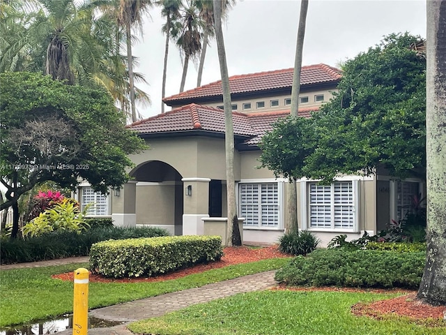 mediterranean / spanish-style house featuring a front lawn