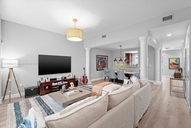 living room with decorative columns and light wood-type flooring