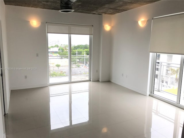 spare room featuring a wealth of natural light and tile patterned flooring