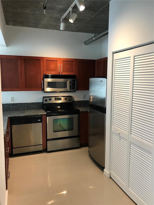 kitchen with rail lighting, stainless steel appliances, and light tile patterned flooring