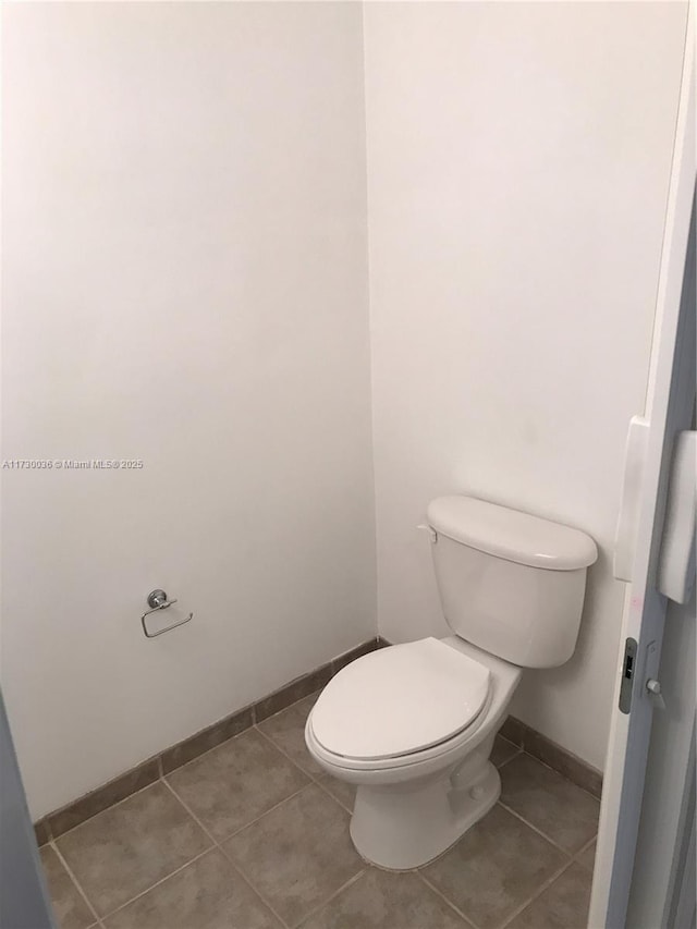 bathroom with toilet and tile patterned floors