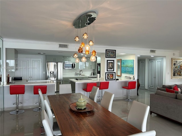 dining room featuring light tile patterned floors and ornamental molding