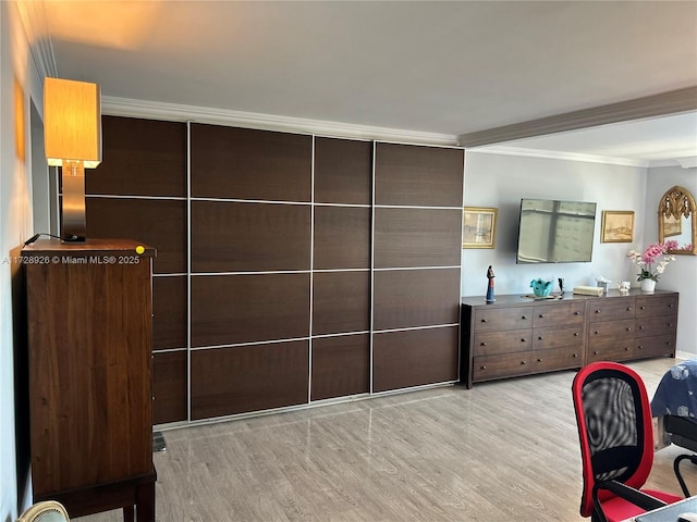 bedroom with ornamental molding and light hardwood / wood-style floors